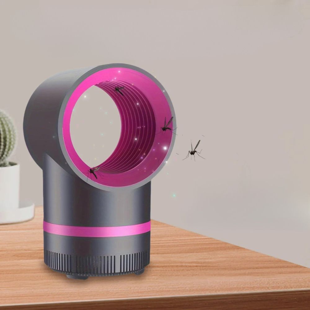 Piège à moustique noir avec tête circulaire rose, posé sur une table en bois.